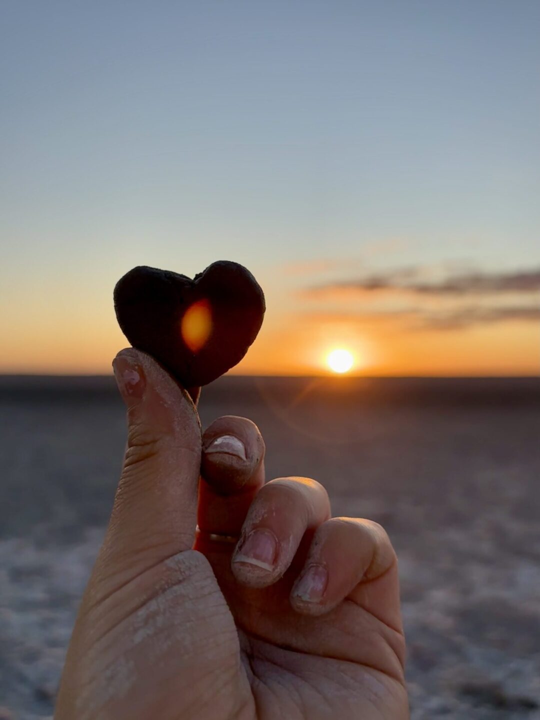 Picture of a hand and the beach sunset
