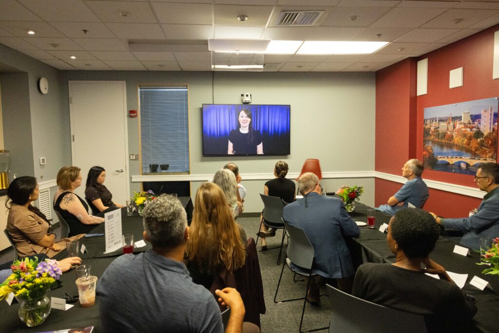 Audience looking at the screen while Fellow is presenting.