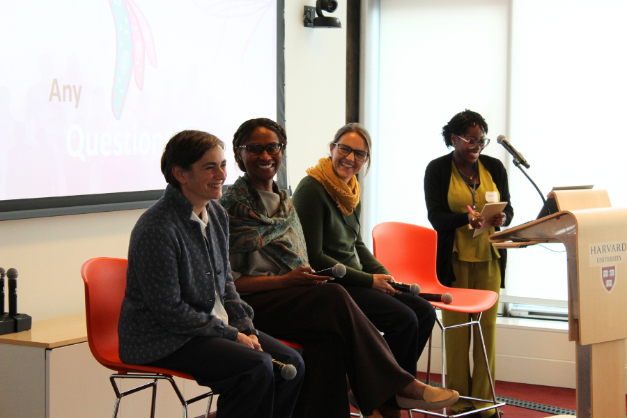 Group of 4 panelists speaking during Q&A in orange high chairs.