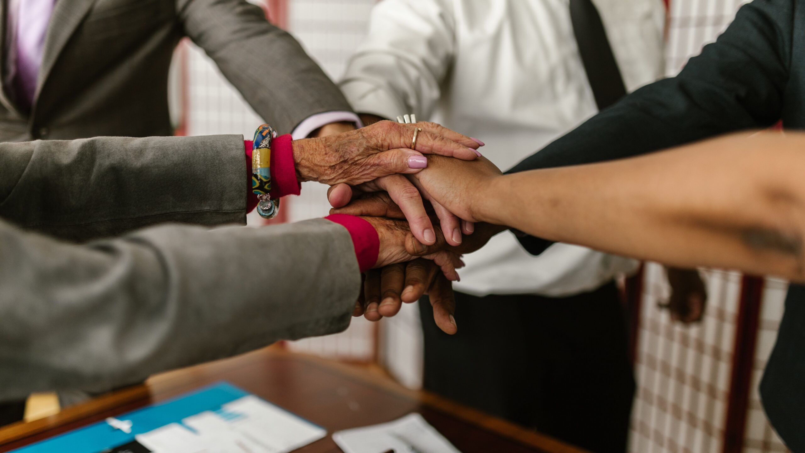 A diverse group of businesspeople uniting their hands symbolizing teamwork and cooperation.